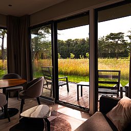Dining area in Holiday Villa Amalia 2, Kotten, overlooking green surroundings.