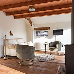 Cozy sitting area in Cottage in Halle, Achterhoek. Vacation home with modern furnishings and views of nature in Gelderland.