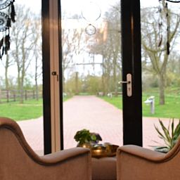 Gezellige zithoek met uitzicht op groene tuin in Vakantiehuisje in Ruurlo, Achterhoek, Gelderland. Ontspannen in landelijke omgeving.