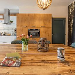 Stijlvolle eetkamer in Huisje in Aalten, vakantiehuis in de Achterhoek, met houten tafel en sfeervolle decoratie.