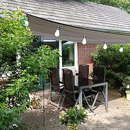 Enjoy the green surroundings on the terrace of Huisje in Aalten, a charming vacation home in the Achterhoek region of Gelderland.