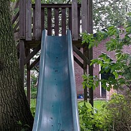 Playground equipment with slide at Huisje in Aalten, vacation home in the green Achterhoek region of Gelderland, ideal for families with children.