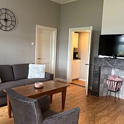 Stijlvolle woonkamer van Huisje in Laren met open haard en toegang tot de keuken in de Achterhoek.