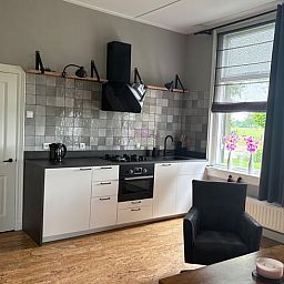 Moderne keuken in Huisje in Laren, vakantiehuis in Gelderland met uitzicht op de tuin.