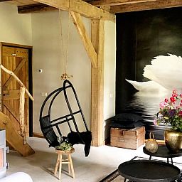 Einzigartige Sitzecke mit Haengesessel und Kamin im Ferienhaus in Vragender, Achterhoek, Gelderland.