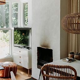 Gezellige woonkamer in vakantiehuis in Lochem met open haard en natuurzicht.