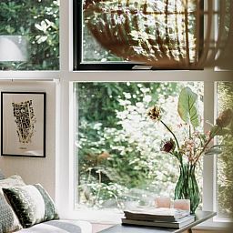 Lichte zithoek in vakantiehuis in Lochem met uitzicht op het groene bos.