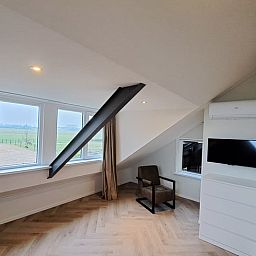 Gezellige zithoek in Vakantiehuisje in Lochem met uitzicht op de groene omgeving van de Achterhoek, Gelderland.