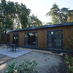 Front of Chalet in Lochem overlooking the green nature of Achterhoek, Gelderland.