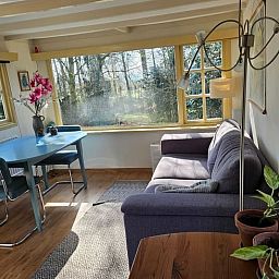 Gemuetlicher Innenbereich des Ferienhauses in Harfsen, Achterhoek, mit Blick auf die Natur vom Wohnzimmer aus in Gelderland.