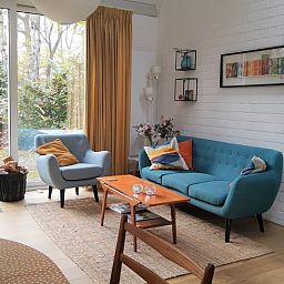 Gezellige woonkamer van Huisje in Harfsen, vakantiehuis in de Achterhoek, Gelderland, met modern interieur en uitzicht op de tuin.