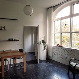 Gemuetlicher Innenbereich des Ferienhauses in Vorden, Achterhoek, Gelderland, mit viel Licht und einem rustikalen Essbereich.