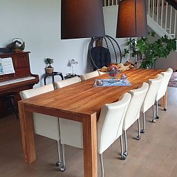 Ruime eetkamer in Vakantiehuis in Vorden Achterhoek, Gelderland, met houten tafel en piano, ideaal voor een ontspannen verblijf.