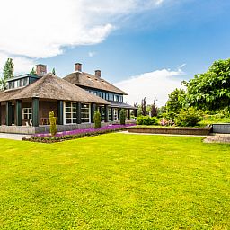Ferienhaus in Doetinchem mit Reetdach, umgeben von einem gruenen Garten in der Region Achterhoek, Gelderland, ideal fuer einen entspannten Aufenthalt.