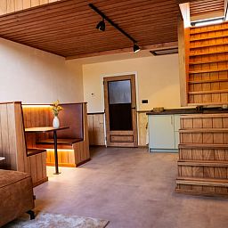 Gezellige binnenruimte van Vakantiehuisje in Neede, Achterhoek, met houten interieur en comfortabele zithoek.