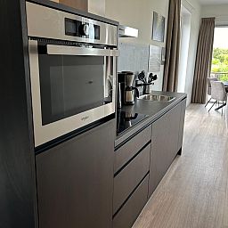 Modern kitchen in the detached house in Olburgen, Achterhoek, Gelderland, overlooking the bright living room and green surroundings.