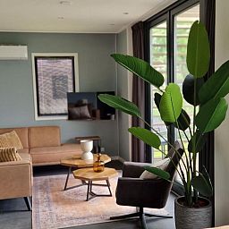 Stilvolles Wohnzimmer in einem freistehenden Haus in Olburgen, Achterhoek, Gelderland, mit moderner Einrichtung und groen Fenstern.