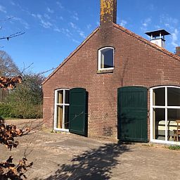 Ferienhaus in Almen, Ferienunterkunft in Achterhoek, Gelderland. Traditionelle Architektur mit Fluegeltueren und sonnigem Aussenbereich.