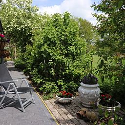 Rustige veranda van Vakantiehuisje in Winterswijk Woold, met uitzicht op het groene landschap van de Achterhoek, Gelderland.