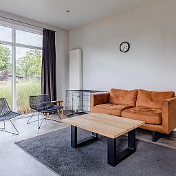Cozy living room in De Vlinderhoeve, a 4-person vacation home in Kring van Dorth, Achterhoek, overlooking the green surroundings.
