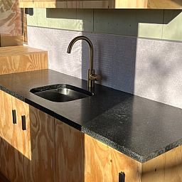 Modern kitchen in Cottage in Winterswijk - Meddo, vacation home in the Achterhoek region, Gelderland. Stylish design with wooden cabinets and natural stone countertops.