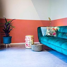 Stijlvolle woonkamer met groene bank in Vakantiehuisje in Joppe, Achterhoek, Gelderland.