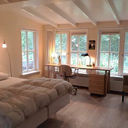 Attraktives Schlafzimmer im Ferienhaus in Joppe, Achterhoek, mit grossem Schreibtisch und Blick auf die gruene Natur in Gelderland.