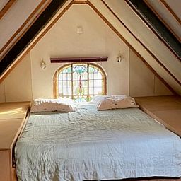 Gemuetliches Schlafzimmer im Ferienhaus in Joppe, Achterhoek, Gelderland mit rustikalem Dachbodenambiente und charmantem Fenster.