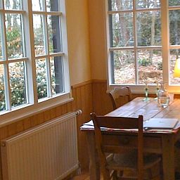 Gemuetliche Essecke im Ferienhaus in Joppe, Achterhoek, mit Blick auf die bewaldete Landschaft von Gelderland.