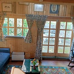 Gemuetlicher Innenbereich des Ferienhauses in Winterswijk Corle, gelegen in Achterhoek, Gelderland, mit Holzinterieur und Blick auf die Terrasse.