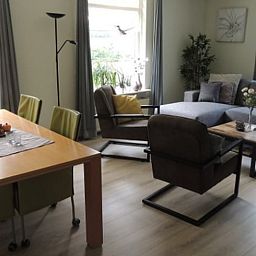Cozy living room of Holiday Home in Winterswijk Corle, Achterhoek, with comfortable sitting area and dining area for a relaxing stay.