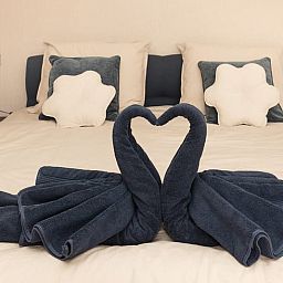 Romantic bedroom in Holiday Home in Wilp-Achterhoek with towel swans on the bed.