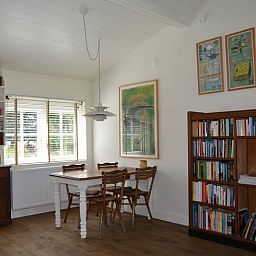 Eetkamer met boekenkast in Vakantiehuis in Varssel - Hengelo Gld, een gezellige plek in de Achterhoek.