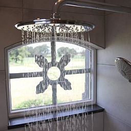 Moderne badkamer in Vakantiehuis in Zieuwent, Achterhoek, met luxe regendouche en uitzicht op de groene natuur van Gelderland.