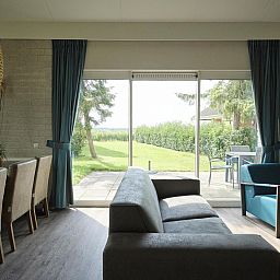 Innenbereich des Bungalows Comfort Deluxe in Elburg mit Blick auf den Garten und viel Tageslicht.