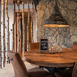 Eetgedeelte in Huisje in Empe, vakantiehuis Gelderland, met houten tafel en rustieke inrichting.