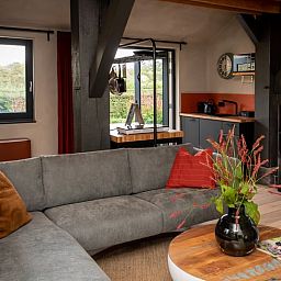 Ruime zithoek in Huisje in Empe, vakantiehuis Gelderse vallei, met uitzicht op de tuin.