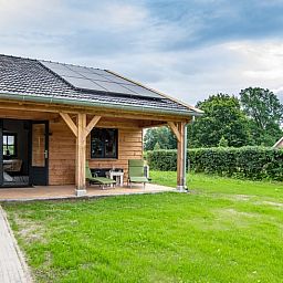 Vakantiehuis in Empe, Gelderse vallei: sfeervol houten vakantiehuis met veranda, omringd door groene natuur in Gelderland.