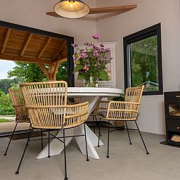 Gezellige eetruimte van Vakantiehuis in Empe, Gelderse vallei, met uitzicht op groene natuur en sfeervolle houtkachel.