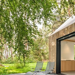 Veranda des Ferienhauses in Tonden, mit Blick auf gruene Waelder.