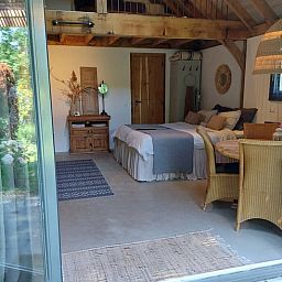 Gezellige binnenruimte van Huisje in Tonden, een vakantiehuis in de Gelderse vallei, Gelderland, met rustieke houten details en tuinzicht.