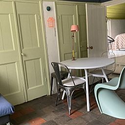 Gemuetlicher Innenraum des Ferienhauses in Voorstonden Gem. Brummen, Ferienhaus im Gelderse Vallei, Gelderland, mit Retro-Interieur und Esstisch.