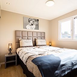 Cozy bedroom in Leijhoeve 4 persons Wellness, a vacation home in Beekbergen, Veluwe, with comfortable beds and natural light.