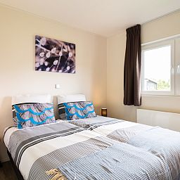Cozy bedroom in Leijhoeve 4-person wellness vacation home, Beekbergen, Veluwe, Gelderland, with modern furnishings and natural light.