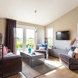 Cozy living room at Leijhoeve 4 persons Wellness in Beekbergen, Veluwe. Holiday home with lots of light and views of the Gelderland countryside.