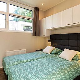 Gemuetliches Schlafzimmer im Modul Special 4 Personen Wellness, Ferienhaus in Beekbergen, Veluwe, mit bequemem Bett und moderner Einrichtung.