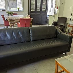 Gemuetliches Wohnzimmer des Ferienhauses in Beekbergen, Ferienhaus in der Veluwe in Gelderland, mit komfortabler Sitzecke und Essbereich.