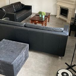 Gemuetliches Wohnzimmer des Ferienhauses in Beekbergen, Ferienhaus in der Veluwe, Gelderland, mit komfortabler Sitzecke und modernem Kamin.