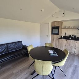 Gemuetlicher Innenbereich des Ferienhauses "Huisje in Harskamp", einem Ferienhaus in der Region Veluwe in Gelderland, mit moderner Kueche und komfortabler Sitzecke.