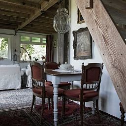 Gezellige binnenruimte van Huisje in Kootwijk, Veluwe, met houten interieur en eethoek.
